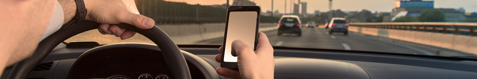 man texting while driving his car